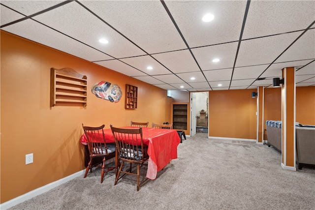 carpeted dining space featuring a drop ceiling