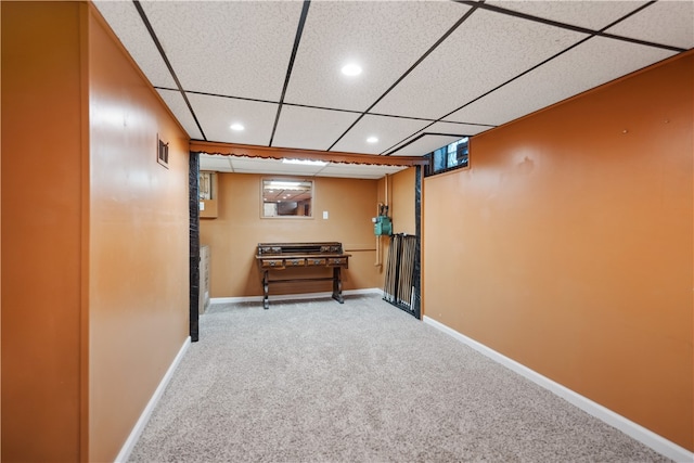 interior space with a paneled ceiling, multiple windows, and carpet floors