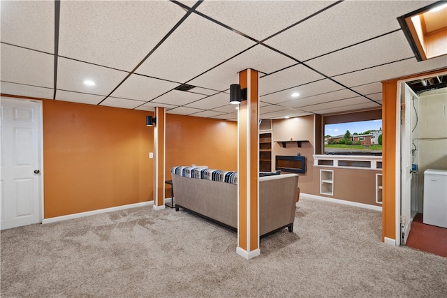 basement featuring a paneled ceiling and light colored carpet