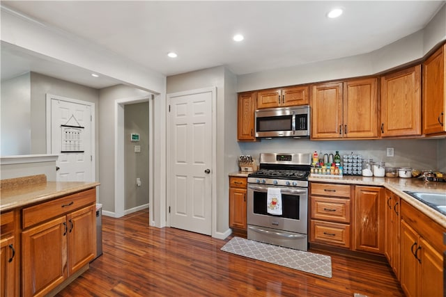 kitchen with appliances with stainless steel finishes and dark hardwood / wood-style floors