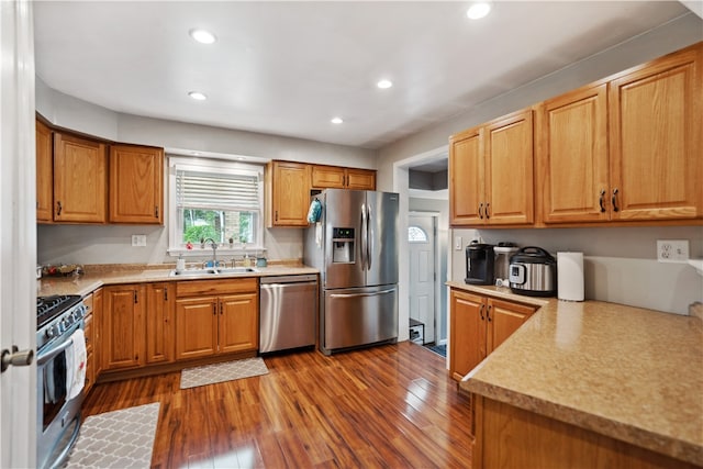 kitchen featuring appliances with stainless steel finishes, dark hardwood / wood-style floors, and sink