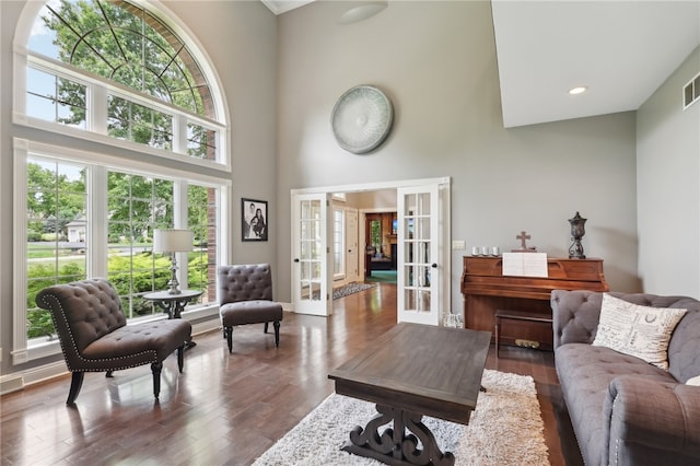 living room featuring french doors, a wealth of natural light, and dark hardwood / wood-style flooring