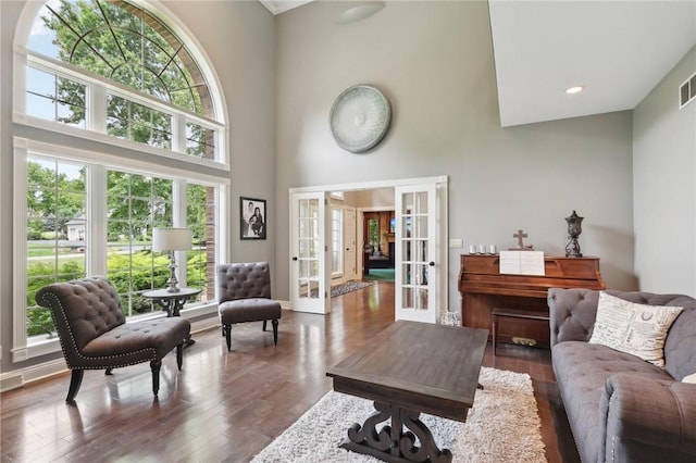 living room featuring french doors, wood finished floors, a towering ceiling, and recessed lighting