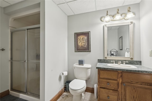 bathroom featuring an enclosed shower, vanity, a drop ceiling, and toilet