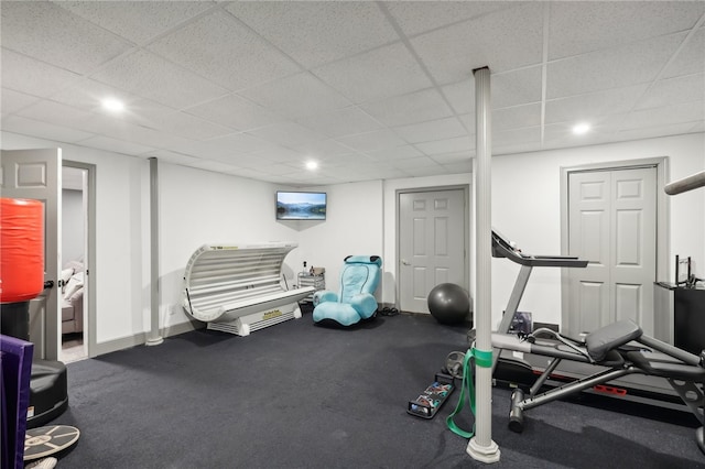 exercise area with a paneled ceiling and carpet flooring