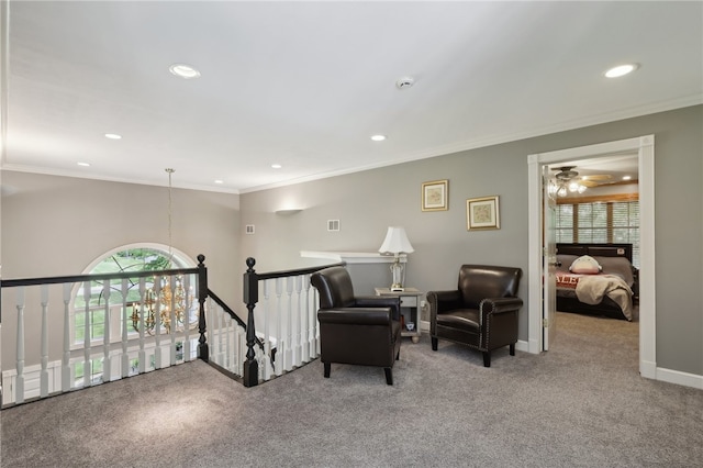 sitting room featuring ceiling fan, ornamental molding, and carpet