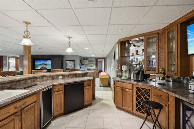 kitchen with dishwasher, a drop ceiling, pendant lighting, and light tile patterned floors