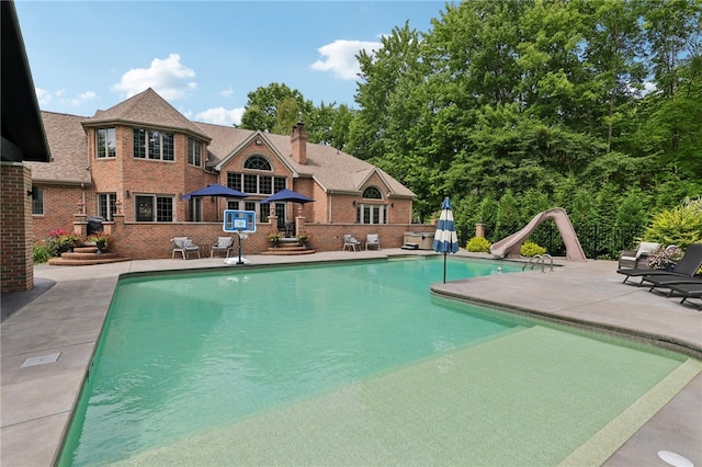 view of pool with a patio area and a water slide