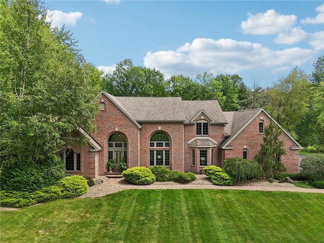 view of front of house featuring brick siding and a front yard