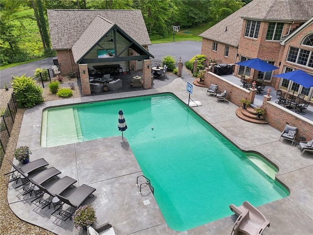 view of pool with outdoor dry bar, a patio, fence, and a fenced in pool