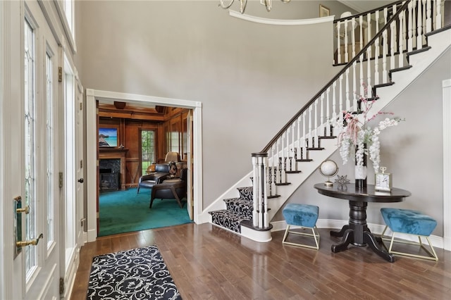 entrance foyer featuring a premium fireplace, wood-type flooring, and a high ceiling