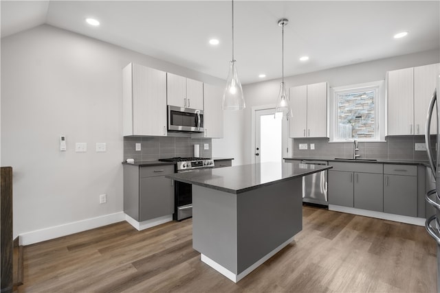 kitchen featuring appliances with stainless steel finishes, dark hardwood / wood-style floors, a kitchen island, and sink