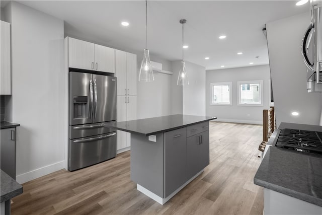 kitchen featuring pendant lighting, a kitchen island, stainless steel appliances, and light wood-type flooring