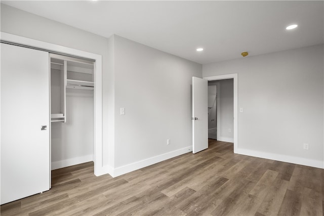 unfurnished bedroom featuring hardwood / wood-style flooring and a closet