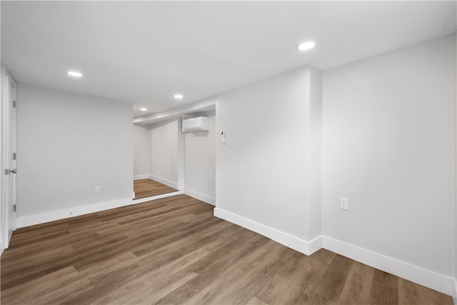 basement featuring hardwood / wood-style flooring and a wall unit AC