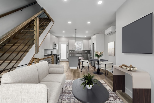 living room with hardwood / wood-style floors and a wall mounted AC