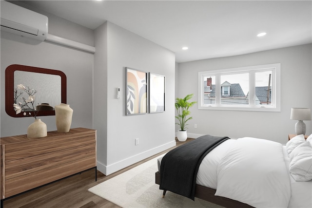 bedroom with a wall mounted air conditioner and dark hardwood / wood-style floors