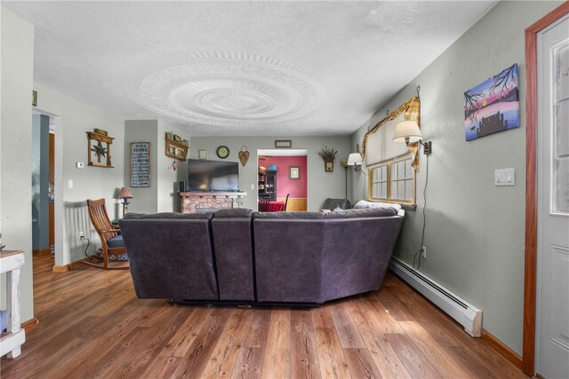 living room with wood-type flooring, a textured ceiling, and baseboard heating