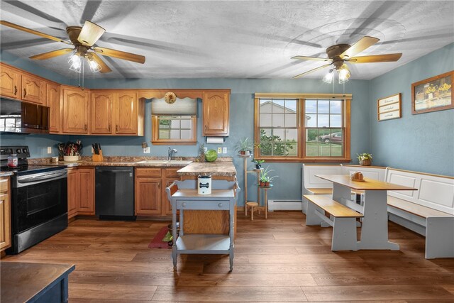 kitchen featuring ceiling fan, a kitchen island, appliances with stainless steel finishes, dark hardwood / wood-style floors, and a baseboard radiator