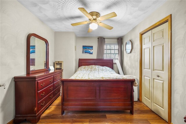 bedroom with ceiling fan, a closet, and dark hardwood / wood-style flooring