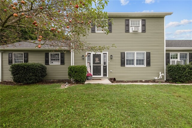 view of front facade with cooling unit and a front lawn