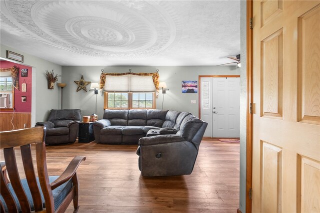 living room featuring a textured ceiling, ceiling fan, and hardwood / wood-style flooring