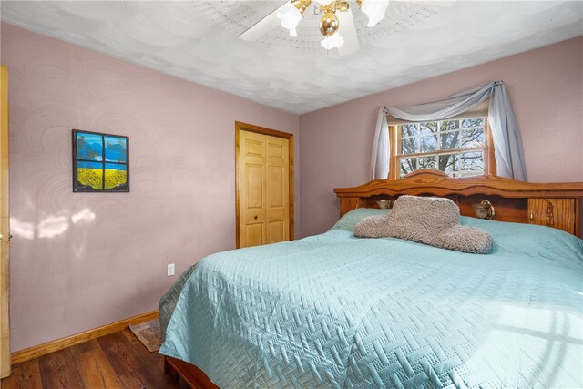 bedroom with wood-type flooring, ceiling fan, and a closet