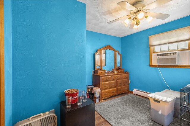 interior space featuring cooling unit, hardwood / wood-style floors, ceiling fan, and a baseboard radiator