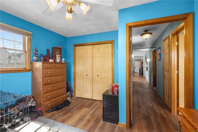 bedroom featuring dark hardwood / wood-style flooring, ceiling fan, and a closet