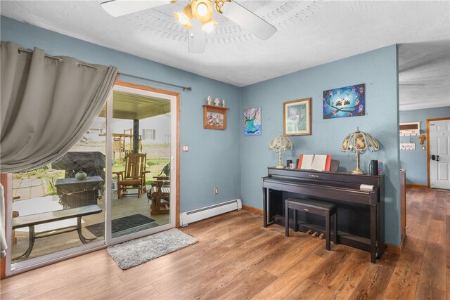 interior space featuring hardwood / wood-style flooring, ceiling fan, and a baseboard radiator