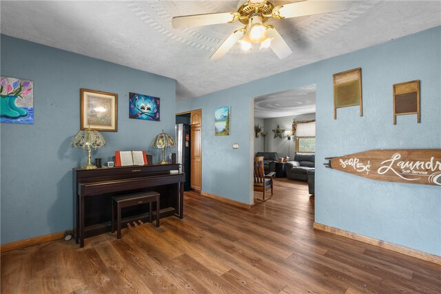 misc room featuring ceiling fan, a textured ceiling, and dark wood-type flooring