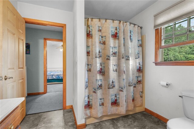 bathroom featuring walk in shower, concrete flooring, ceiling fan, vanity, and toilet