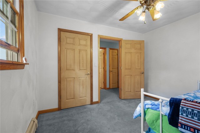 carpeted bedroom with ceiling fan and a baseboard heating unit