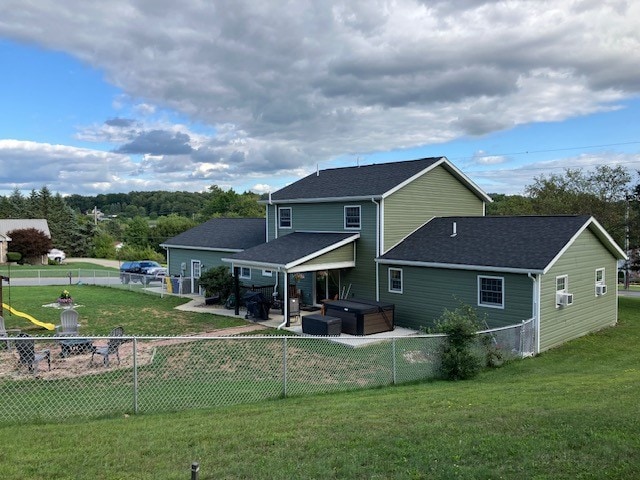 rear view of house featuring cooling unit, a yard, a patio, and a hot tub