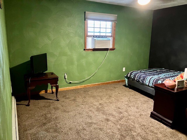 bedroom with carpet floors, cooling unit, and baseboard heating