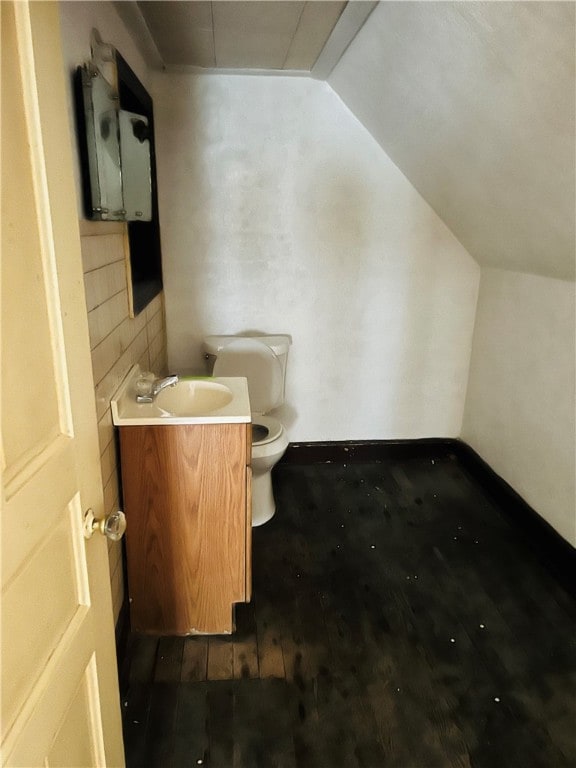 bathroom featuring vaulted ceiling, vanity, and toilet