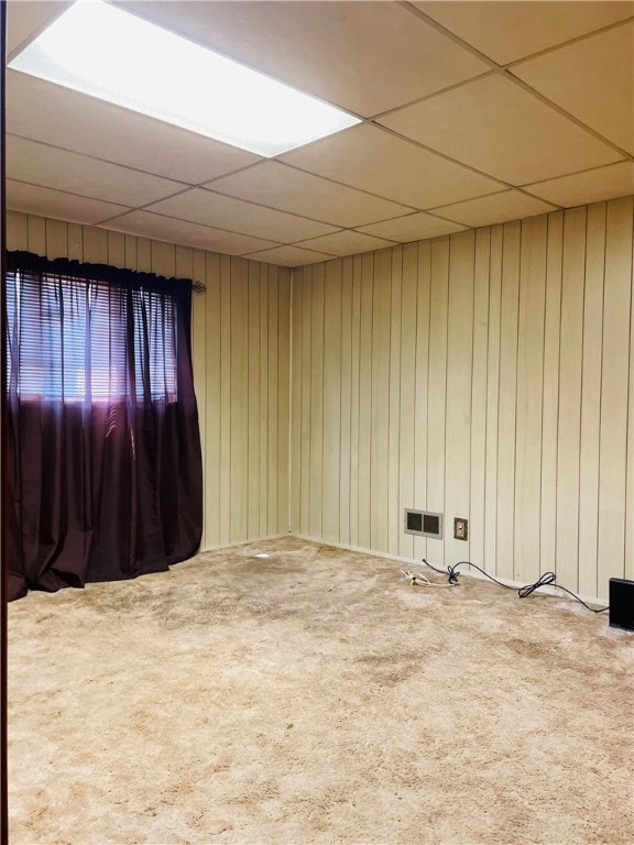 unfurnished room with carpet and a paneled ceiling