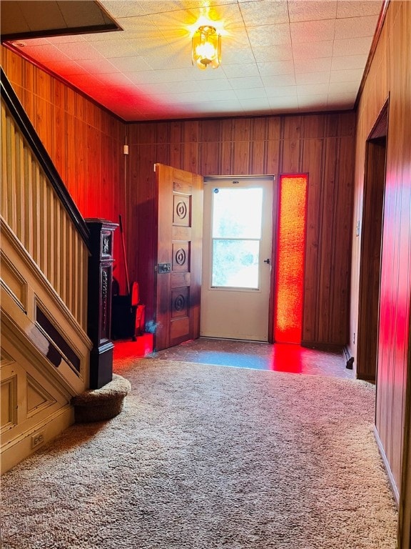 interior space with carpet flooring and wooden walls