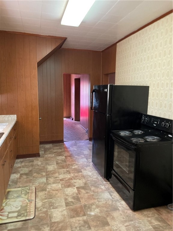 kitchen with wood walls, black / electric stove, and light colored carpet