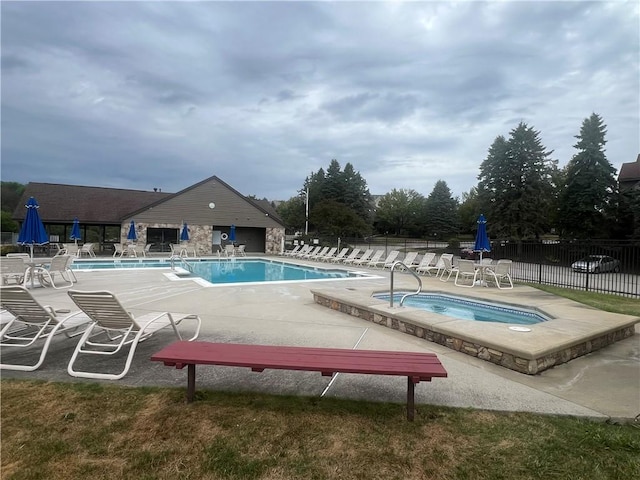 view of swimming pool featuring a patio area and a hot tub