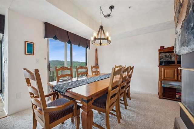 dining space featuring light colored carpet and a chandelier