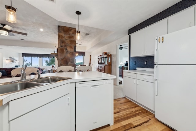 kitchen featuring white appliances, white cabinets, decorative light fixtures, light hardwood / wood-style floors, and sink