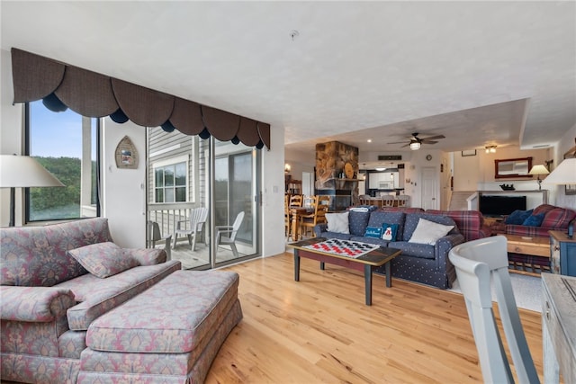 living room featuring ceiling fan and light hardwood / wood-style flooring