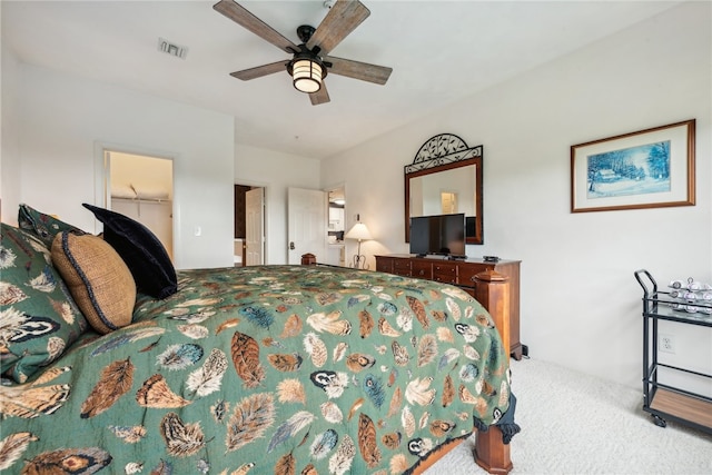 carpeted bedroom with ceiling fan, a spacious closet, and a closet