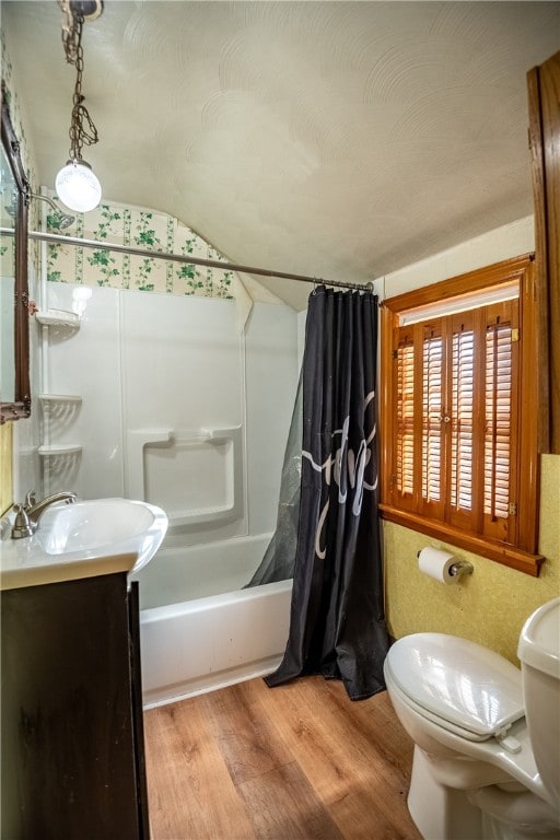 full bathroom with shower / bath combo with shower curtain, hardwood / wood-style flooring, toilet, vanity, and vaulted ceiling