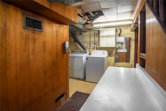 laundry area featuring washing machine and dryer and wooden walls