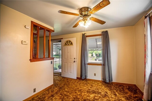 carpeted spare room with ceiling fan