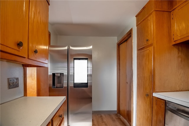 kitchen featuring appliances with stainless steel finishes and light hardwood / wood-style flooring