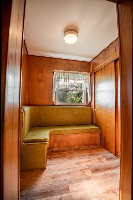 mudroom featuring wood-type flooring and wooden walls