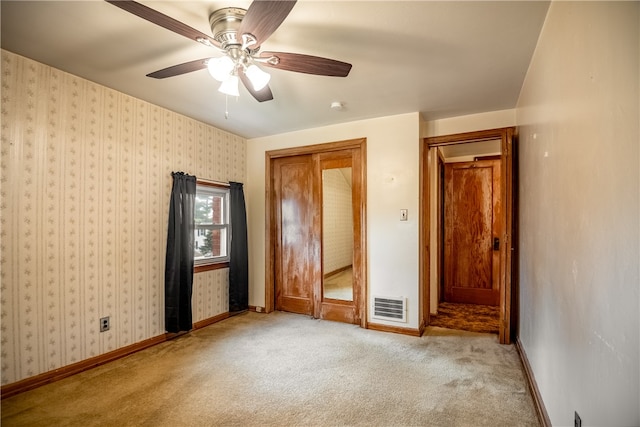 unfurnished bedroom featuring light carpet and ceiling fan